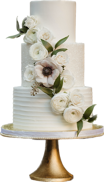 A three-tiered white wedding cake with textured frosting, decorated with white roses and a large anemone flower, displayed on a gold cake stand.