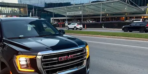 Black GMC Yukon XL Denali SUV parked outside a modern glass building