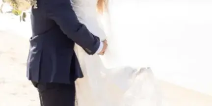 A bride and groom kissing on a beach with the text 'bridal artistry On Location Makeup & Hair Styling' overlaid.