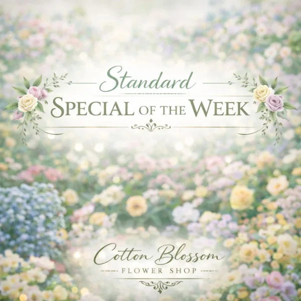 A floral arrangement featuring pink and cream roses with green leaves, set against a blurred background of a flower field.