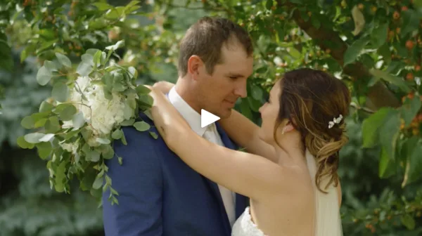 A bride and groom sharing a moment outdoors, with the bride holding a bouquet.