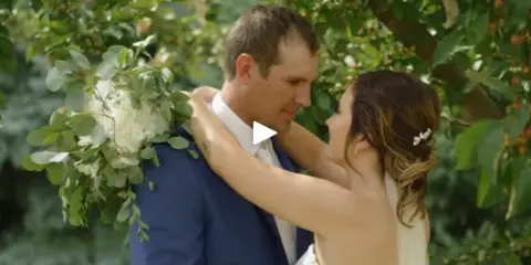 A bride and groom sharing a moment outdoors, with the bride holding a bouquet.