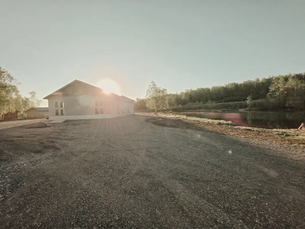 Lakefront event venue building with gravel parking area and water view at sunset