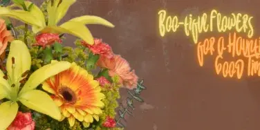 A colorful bouquet of yellow lilies, orange roses, and gerbera daisies arranged against a brown background with neon-style text.