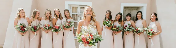 Bride and bridesmaids with styled hair and makeup holding bouquets