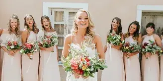 Bride and bridesmaids with styled hair and makeup holding bouquets