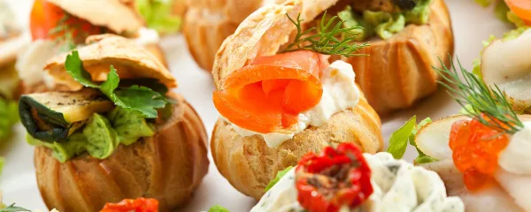 Close-up of assorted gourmet canapés and appetizers on a white plate.