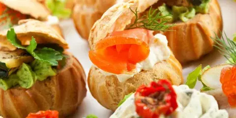 Close-up of assorted gourmet canapés and appetizers on a white plate.