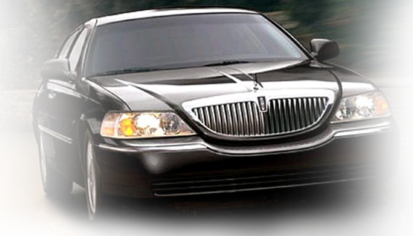 Black Lincoln town car driving on a road