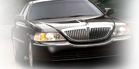 Black Lincoln town car driving on a road