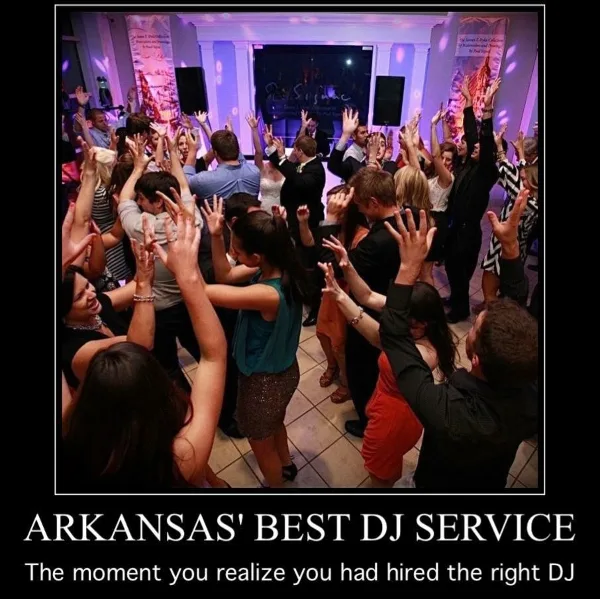 A crowded dance floor at a wedding reception with guests dancing and raising their hands under purple lighting.