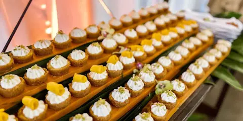 A long wooden platter filled with rows of small, garnished appetizers.