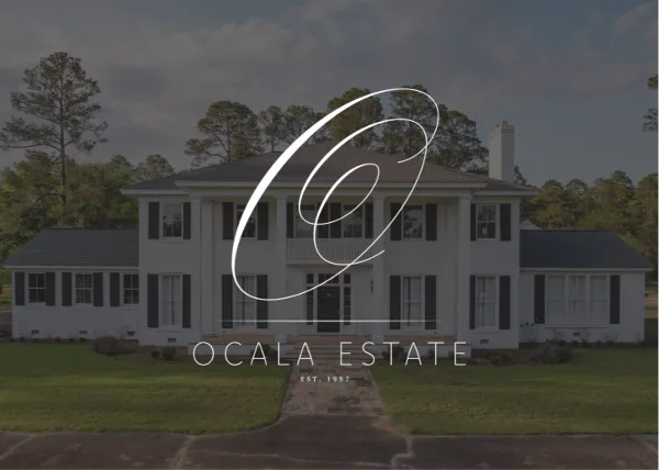 Exterior view of the Ocala Estate historic Southern manor with a white facade, dark shutters, and a front lawn.