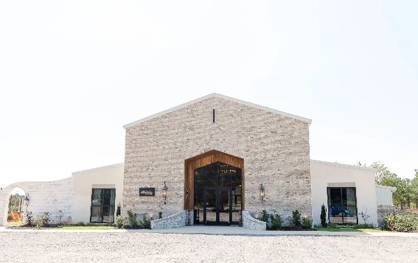 Exterior view of the BellaWood the Venue building featuring a brick facade and large wooden entrance.