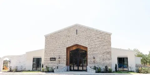 Exterior view of the BellaWood the Venue building featuring a brick facade and large wooden entrance.