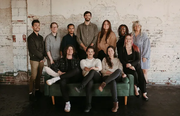 Group photo of the Alumni Productions team members posing in a studio setting.
