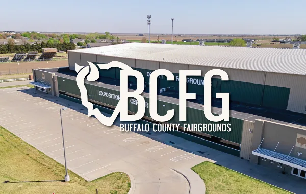 Aerial view of the Buffalo County Fairgrounds Exposition Center building with a parking lot and surrounding grounds.
