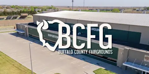 Aerial view of the Buffalo County Fairgrounds Exposition Center building with a parking lot and surrounding grounds.