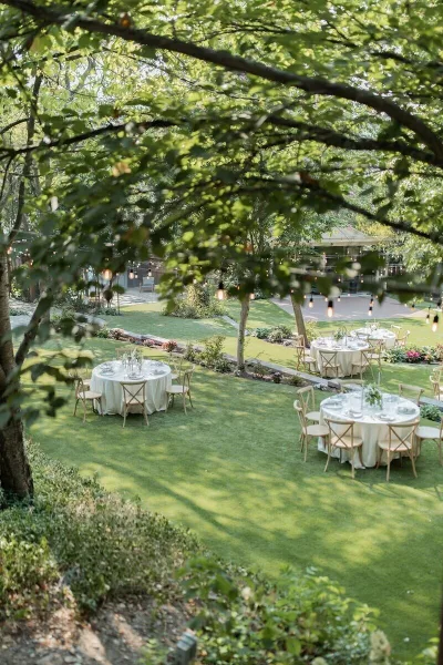 Outdoor garden wedding reception with round tables and string lights