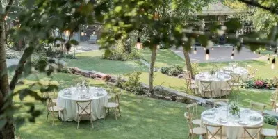 Outdoor garden wedding reception with round tables and string lights