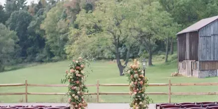 Outdoor wedding ceremony aisle decorated with floral arrangements and markers