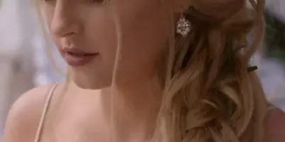 A bride with an elegant, braided updo hairstyle and professional makeup.