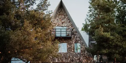 Exterior view of the stone-clad A-frame building at the Stone Crossing estate venue.