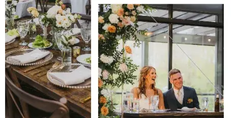 A wedding reception table set with white plates, gold cutlery, glassware, and floral centerpieces, with a bride and groom seated at a head table.