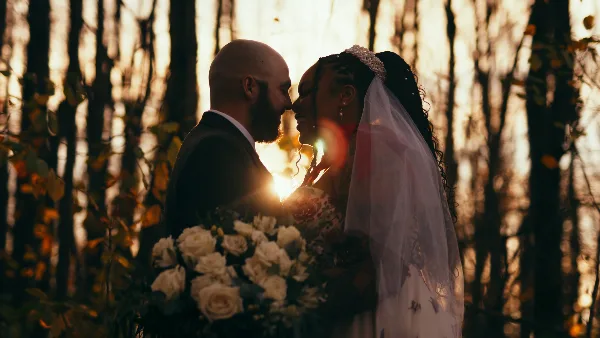 Cinematic backlit portrait of a bride and groom in a forest setting