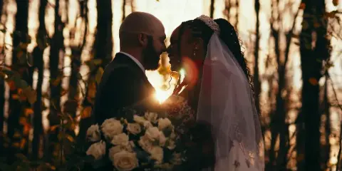Cinematic backlit portrait of a bride and groom in a forest setting