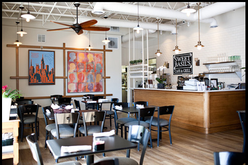 Interior view of Sweet Basil's Cafe showing dining tables, chairs, and a service counter.