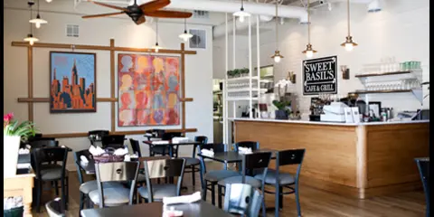 Interior view of Sweet Basil's Cafe showing dining tables, chairs, and a service counter.