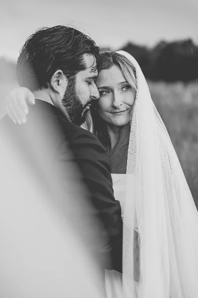 Black and white portrait of a bride and groom embracing outdoors