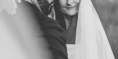 Black and white portrait of a bride and groom embracing outdoors