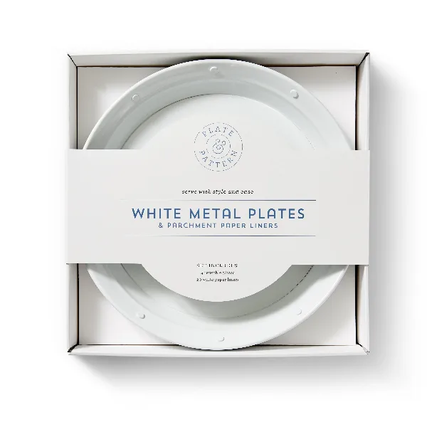 A set of white metal plates and parchment paper liners in a white box.
