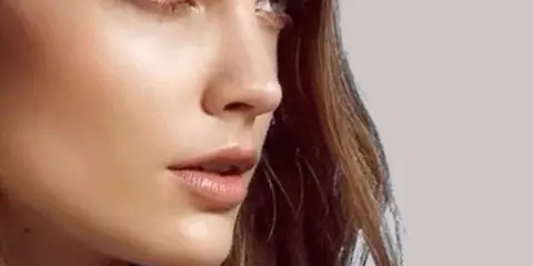 Close-up portrait of a woman with professional makeup and styled hair.