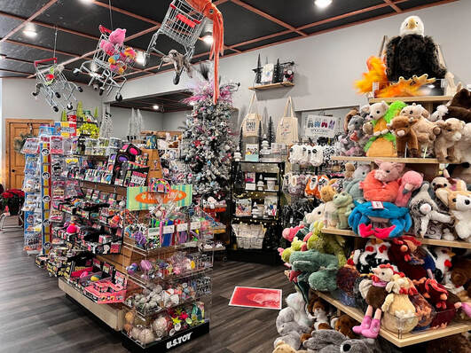 Interior view of a florist and gift shop displaying shelves of plush toys, greeting cards, and floral arrangements.