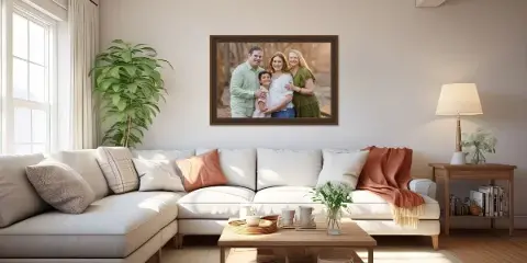 A framed family portrait photograph hanging on a wall above a sofa in a living room.