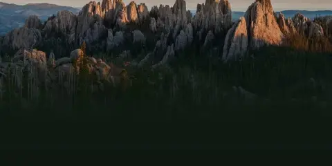 Granite mountain spires and pine forest in the Black Hills at sunset