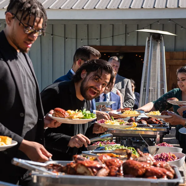 Catering staff serving food to guests at an outdoor event