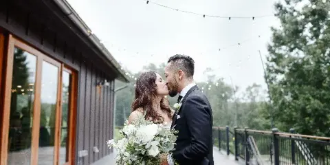 Wedding couple holding a white floral bouquet by Petals and Twigs