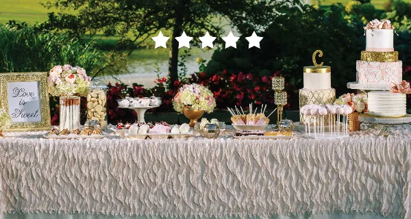 A wedding dessert table featuring multi-tiered cakes, cupcakes, and assorted sweets.
