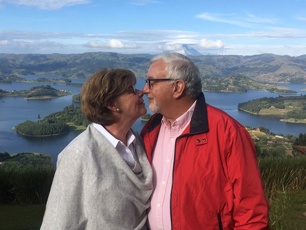 Portrait of Dr. Richard Pulice, the wedding officiant, standing with a partner in a scenic outdoor location.