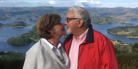 Portrait of Dr. Richard Pulice, the wedding officiant, standing with a partner in a scenic outdoor location.