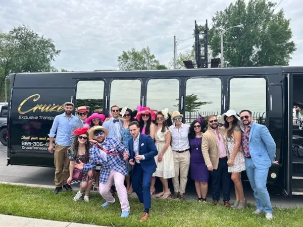 A group of people posing in front of a black Cruze Transport party bus