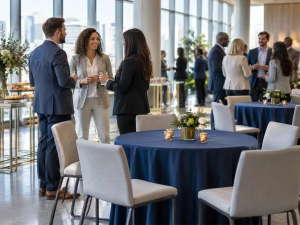 Guests mingling beside event tables at an indoor business reception