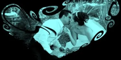 A stylized, monochromatic photo of a bride and groom kissing, framed within a decorative heart shape.