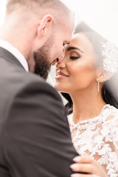 A close-up fine art wedding photograph of a bride and groom touching foreheads.