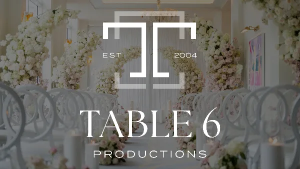 A luxury wedding ceremony aisle featuring white chairs, candles, and large floral arrangements with a Table 6 Productions logo overlay.