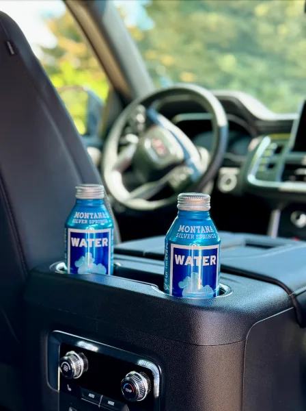 Interior of a luxury SUV with Montana Silver Springs water bottles in the cup holders.